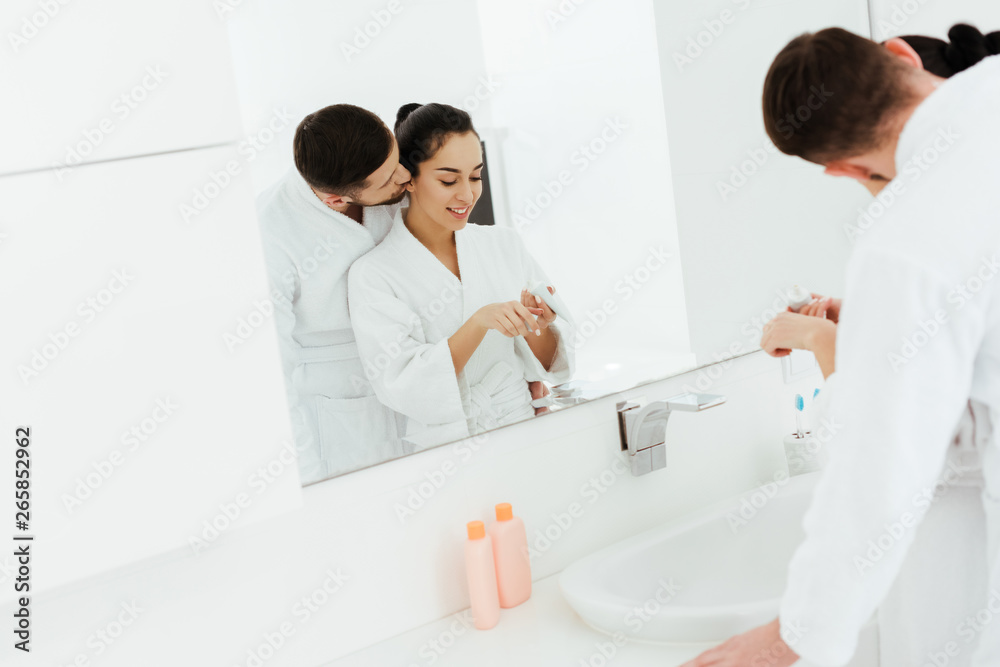 selective focus of boyfriend kissing cheek of girlfriend with toothpaste selective focus of boyfriend kissing cheek of girlfriend with toothpaste