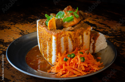 A Durban Bunny Chow - or quarter mutton bunny - served with sambals. This is an iconic Durban meal consisting of a section of a loaf of bread hollowed out and filled with mutton curry and gravy.