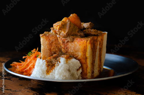 A Durban Bunny Chow - or quarter mutton bunny - served with sambals. This is an iconic Durban meal consisting of a section of a loaf of bread hollowed out and filled with mutton curry and gravy.