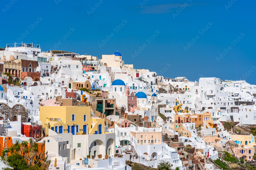 OIA, SANTORINI - APRIL 07, 2019: Oia is a popular tourist coastal town on Greek Aegean island Santorini famous for it's whitewashed houses carved into the rugged clifftops