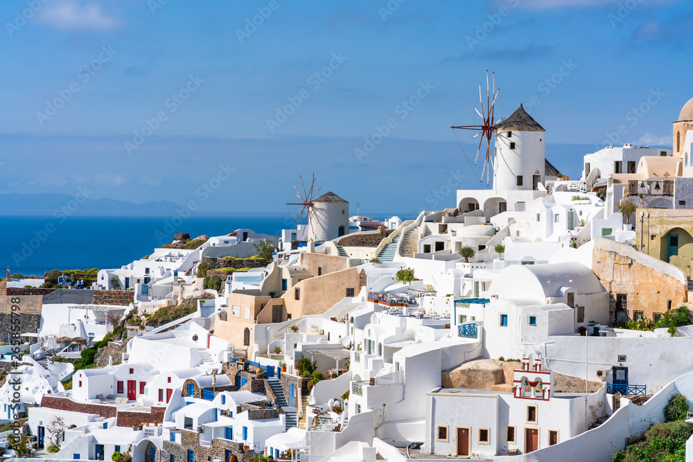 View of Oia town with traditional white windmills on Cyclades island of Santorini, Greece