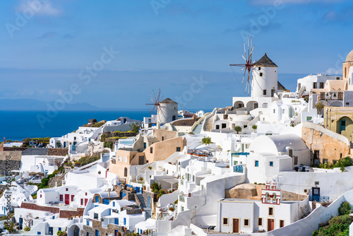 View of Oia town with traditional white windmills on Cyclades island of Santorini, Greece © beataaldridge