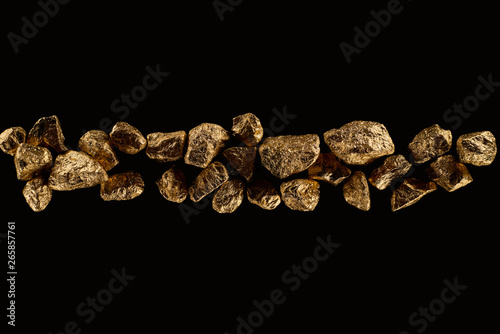 top view of golden textured stones arranged in row isolated on black