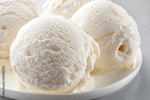 ice cream scoops  on white plate macro  against neutral background