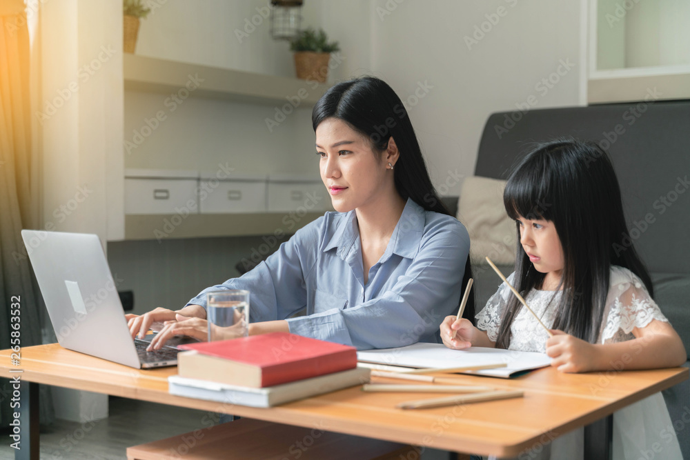 Beautiful business mom is using a laptop with kids at home Beautiful business mom is using a laptop with kids at home