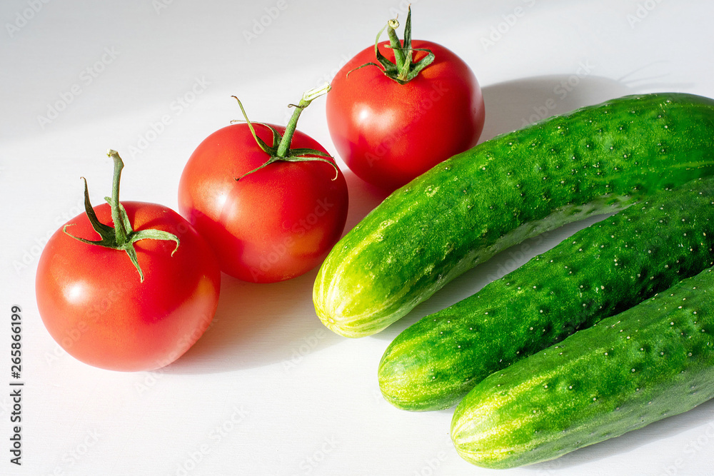 Close-up of fresh, ripe tomatoes and cucumbers on a wood background Close-up of fresh, ripe tomatoes and cucumbers on a wood background
