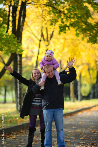 The happy family walks on the autumn park