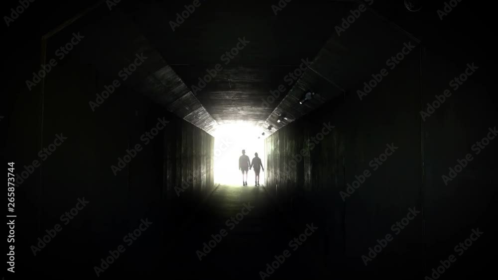 Silhouette of a couple on bright background at the end of an underground pedestrian tunnel
