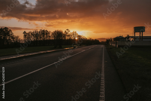 Sunrise landscape in the countryside with a road and a hiking path.