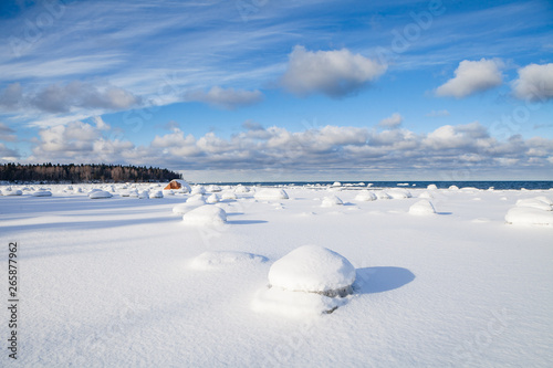 Frozen coast of Baltic sea covered by snow. Boulders, horizon and forest © yegorov_nick