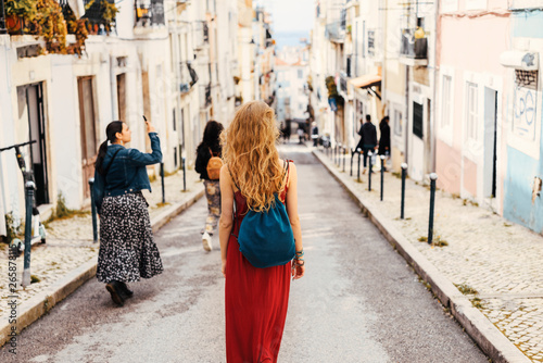 Photography Woman in red dress exploring narrow streets of european city streets