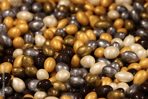 Colorful candy, selective focus. Gold, silver, chocolate and pearl sweets, pile of candies for background