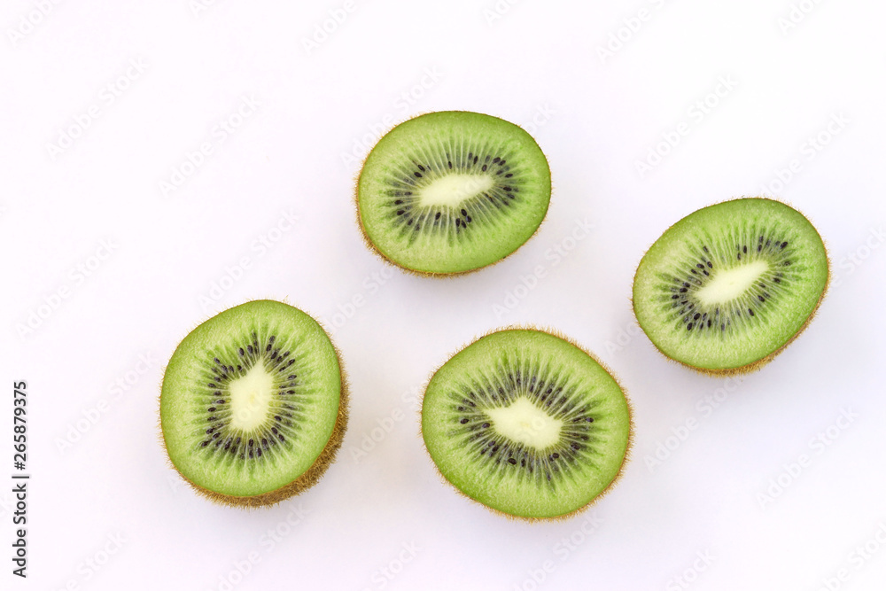 Fototapeta premium Kiwi halves are located on a white background