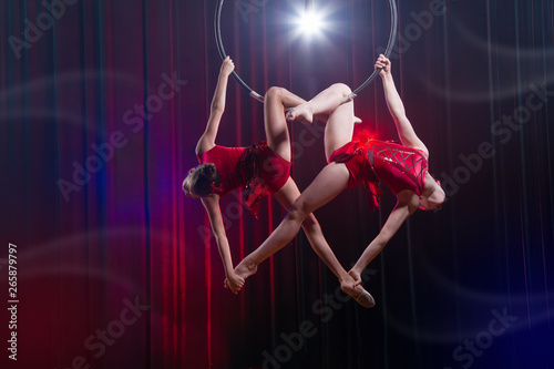 Circus actress acrobat performance. Two girls perform acrobatic elements in the air ring.