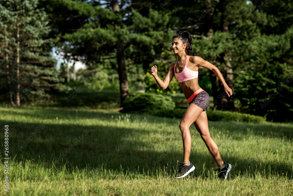 Young female runner jogging during outdoor workout in a park. Beautiful fit girl. Weight Loss. Sport LIfestyle. Young female runner jogging during outdoor workout in a park. Beautiful fit girl. Weight Loss. Sport LIfestyle.