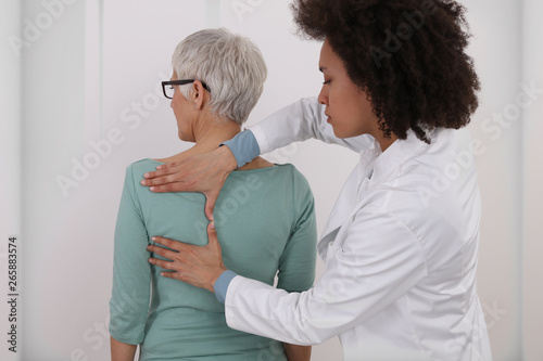Woman having chiropractic back adjustment. Osteopathy, Physiotherapy, Injury rehabilitation concept