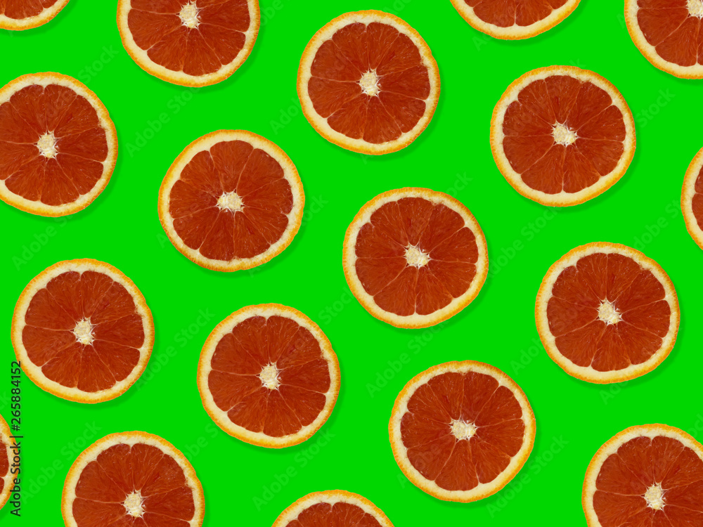 Creative pattern made of red oranges. top view of colorful fruit pattern of fresh red orange slices on green colorful background. Creative pattern made of red oranges. top view of colorful fruit pattern of fresh red orange slices on green colorful background.