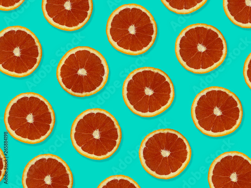 Creative pattern made of red oranges. top view of colorful fruit pattern of fresh red orange slices on blue colorful background. 