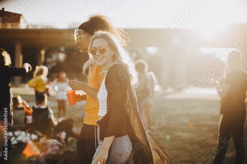 Smiling woman walking with friend at concert