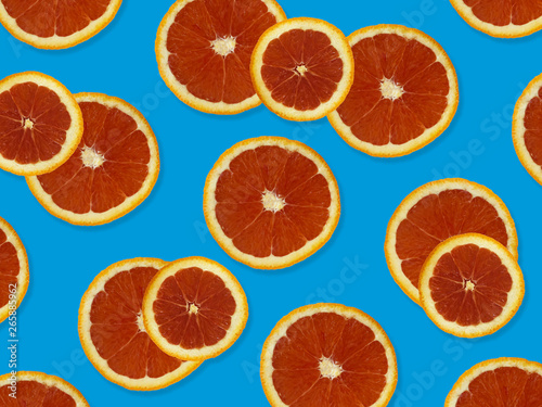Creative pattern made of red oranges. top view of colorful fruit pattern of fresh red orange slices on blue colorful background. 