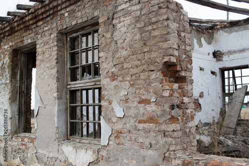 Fototapeta Naklejka Na Ścianę i Meble -  broken windows and the crumbling part of an abandoned old building