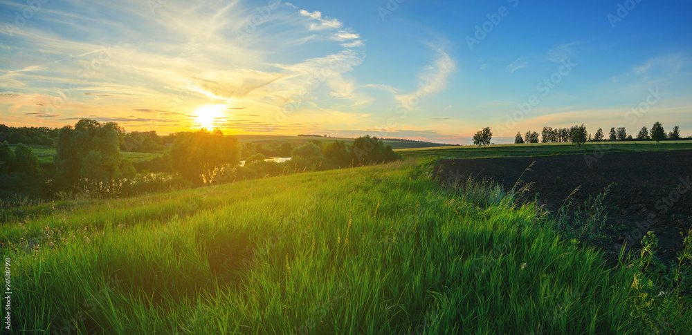 Beautiful view of green hills and fields at sunset