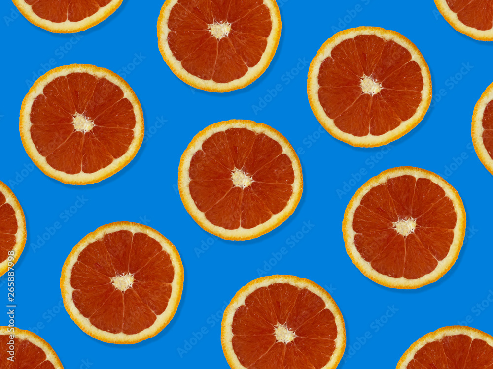 Creative pattern made of red oranges. top view of colorful fruit pattern of fresh red orange slices on blue colorful background. Creative pattern made of red oranges. top view of colorful fruit pattern of fresh red orange slices on blue colorful background.