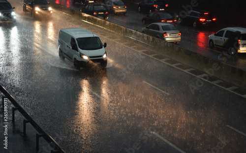 delivery van speeding by highway in rainy night