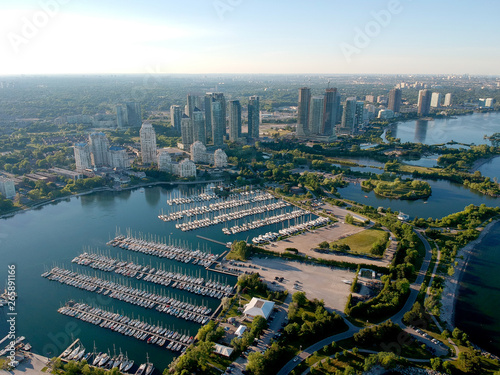 Photography Aerial bird eye shot over Humber Bay Shores Park, Toronto, Canada with coastal condo homes, blue skies, beaches and harbour entrance in view with glass condominiums