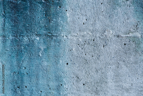 Grey and blue abstract textured grunge wall background for use in design. Wall fragment with cracks, scratches 
