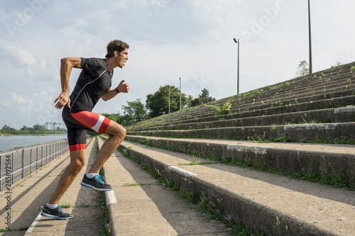 Male athlete climbing stairs intensely training for triathlon photo