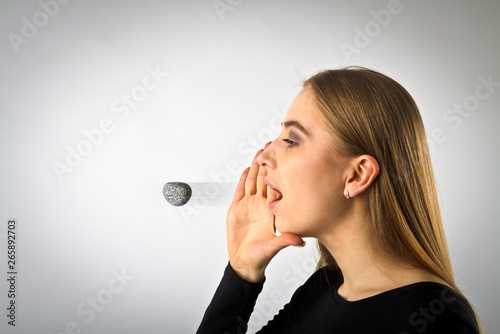 Young woman in black is screaming at something. Screaming. Word like a stone.