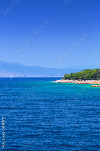 The coast between the islands of Krk and Cres in the Adriatic Sea in Croatia. Wonderful romantic summertime seascape with crystal clear azure sea and emerald green coastline slopes.