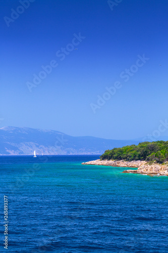 The coast between the islands of Krk and Cres in the Adriatic Sea in Croatia. Wonderful romantic summertime seascape with crystal clear azure sea and emerald green coastline slopes.