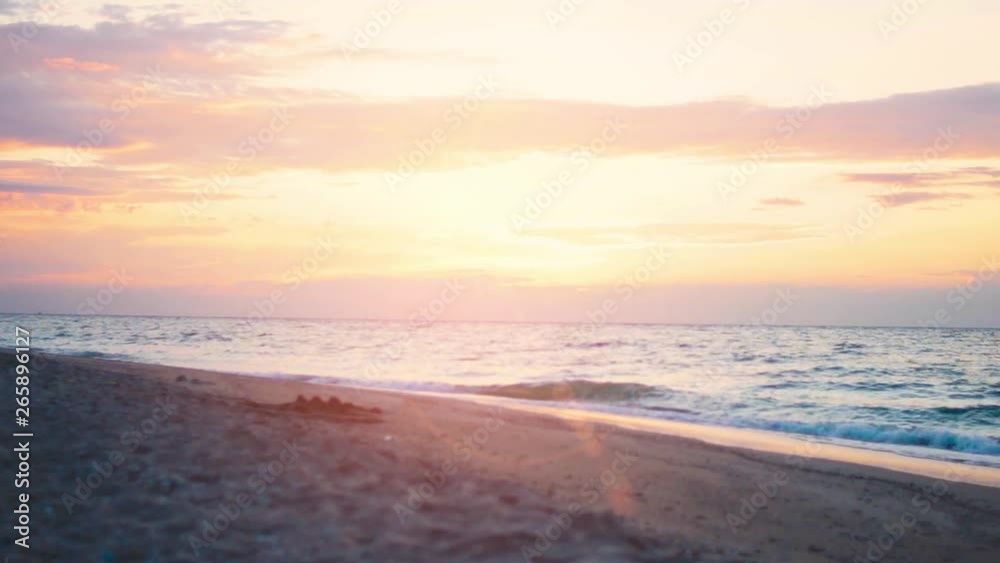 Empty sandy beach at sunrise (sunset). Waves roll on the sandy shore. Fixed Camera Empty sandy beach at sunrise (sunset). Waves roll on the sandy shore. Fixed Camera