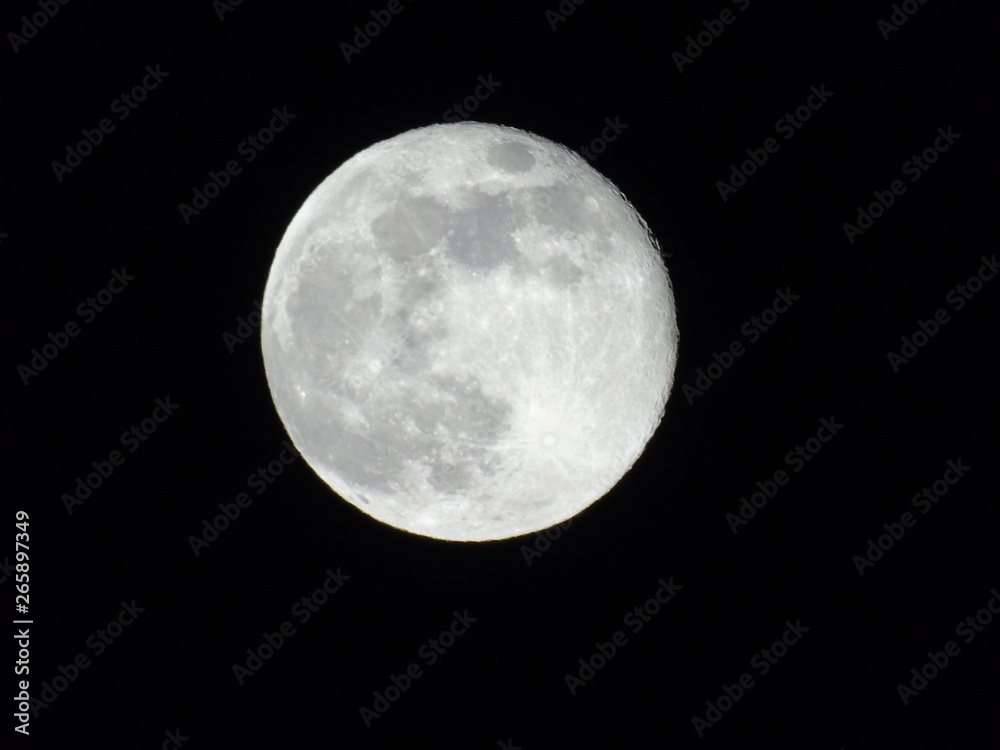 Obraz premium Genova, Italy - 03/22/2019: An amazing photography of the full moon over the city of Genova by night with a great clear sky in background and some stars