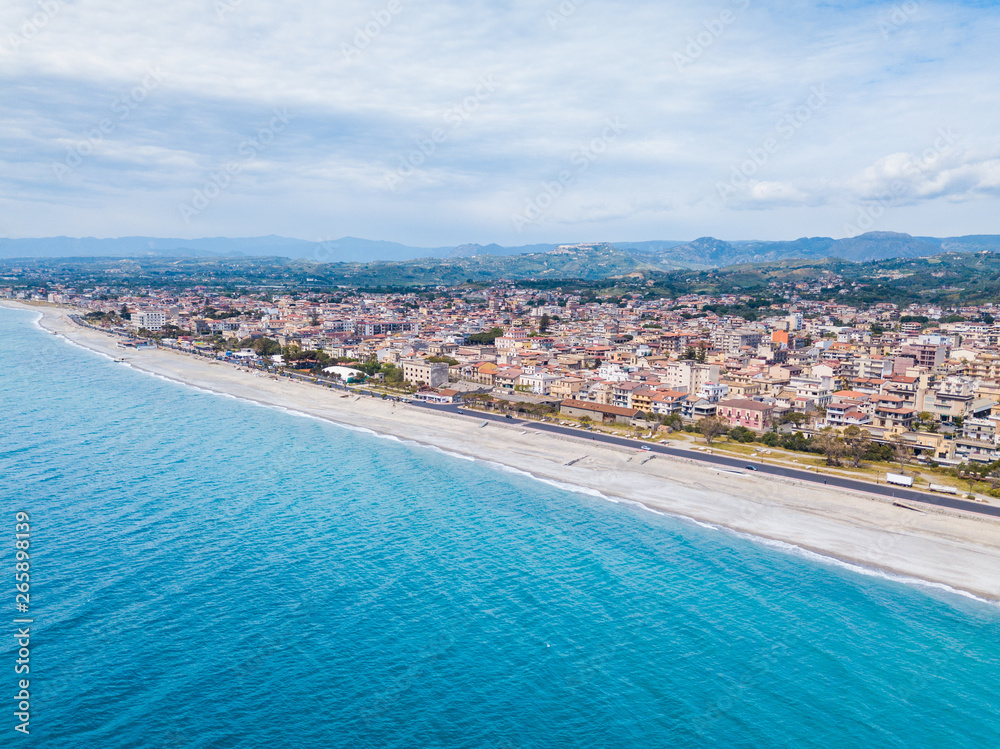 Obraz premium Città costiera di Siderno in Calabria, vista aerea. Meta turistica in Estate e della Locride. Lungomare rifatto, strade e case in campagna.