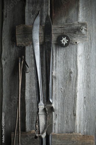 Old skis and ski poles leaning on wooden wall, Edelweiss photo