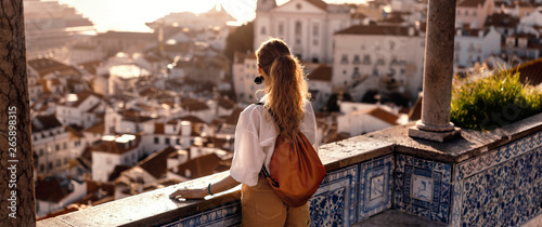 Female tourist looking at old town from balcony