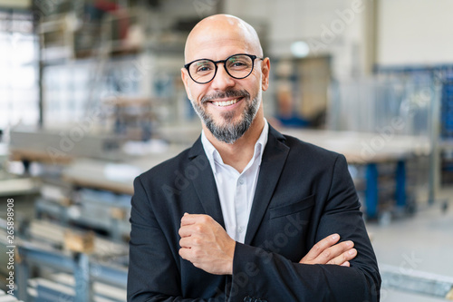Portrait of smiling businessman in factory photo