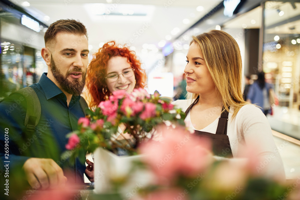 Shop assistant advising couple in flower shop