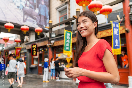 Photography China food market tourist woman walking using phone on Beijing hutong street travel vacation adventure