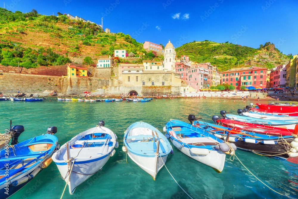 Vernazza village in Cinque Terre National park, Italy. Coastline landscape with colorful wooden fishing boats and beautiful medieval architecture of Vernazza town in background. UNESCO heritage site.