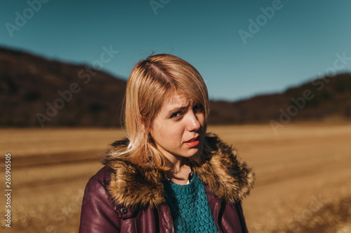 Blonde young woman walking on the beach on a chilly winter day