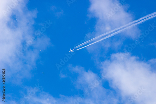 Airplane contrail against blue sky with copy space