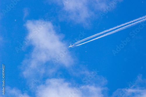 Airplane contrail against blue sky with copy space