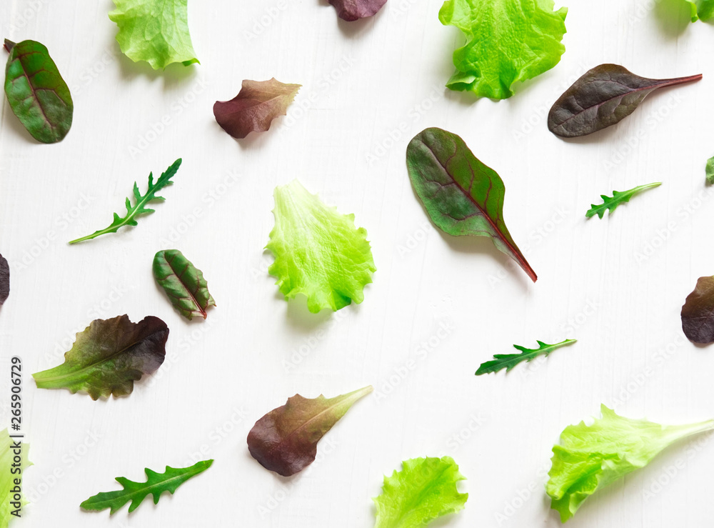 Pattern with lettuce for the background on the site. Salad greens and dietary products. Proper nutrition and vegetarianism. Background with lettuce leaves. Flat lay, top view.