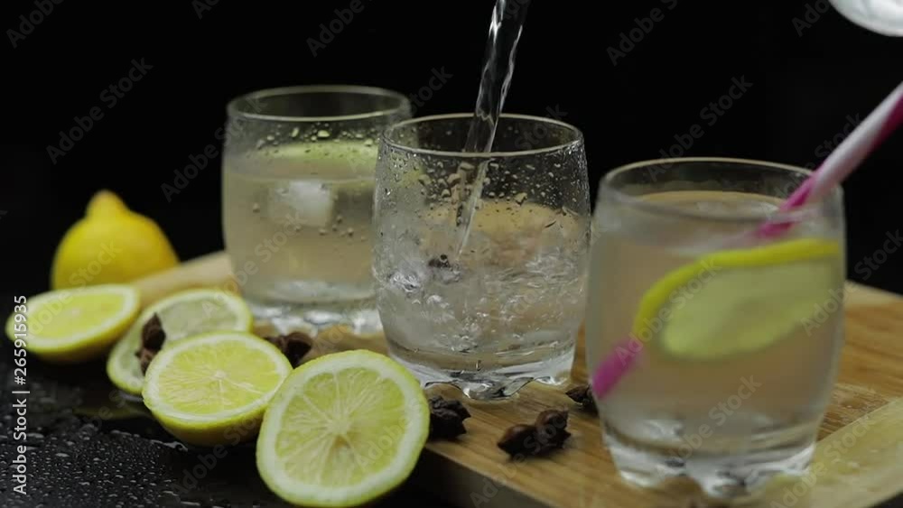 Pour lemon juice into glass with ice and lemon slices. Lemon alcoholic cocktail Pour lemon juice into glass with ice and lemon slices. Lemon alcoholic cocktail