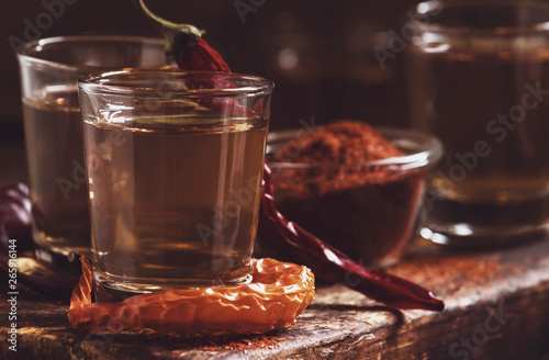 Ukrainian vodka with pepper gorilka, dark vintage wooden table, rustic style, selective focus photo