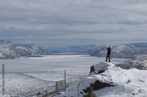 man pointing frozen lake
